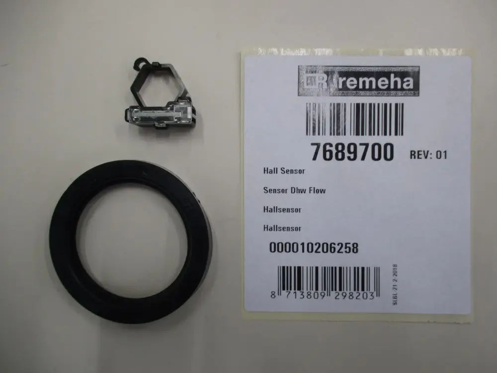 Sensor von Remeha mit zwei Komponenten: einem Hall-Sensor und einem ringförmigen Anschluss. Verkäuferinformationen und Barcode sind auf dem beigefügten Etikett zu sehen.